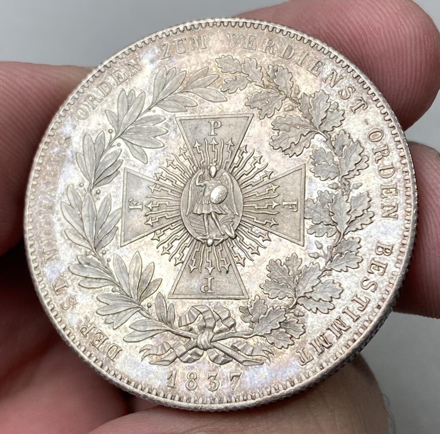 万国钱币拍卖第062期 1837巴伐利亚圣·米迦勒勋章历史大泰勒 路德维希一世在1837年修改此勋章的宗教和军事属性 将其指定为功绩勋章 授予被国王认可做出杰出贡献的人 并发行历史泰勒加以纪念 勋章中央为大天使长圣·米迦勒 手持闪电之剑 脚踩恶魔 欧陆淡五彩收藏级