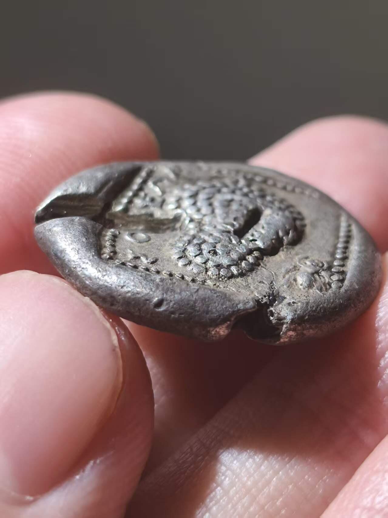 星盘世界钱币拍卖 古典时期- 古希腊 索洛伊斯塔特厚重大银币 约公元前440-410年。正面：亚马逊女战士跪于左侧，箭筒和弓袋置于身侧，手持弓箭；左侧有常春藤叶，右侧有头盔。背面：葡萄串；左侧有“ΣOΛEΩN”字样，有一些验银痕