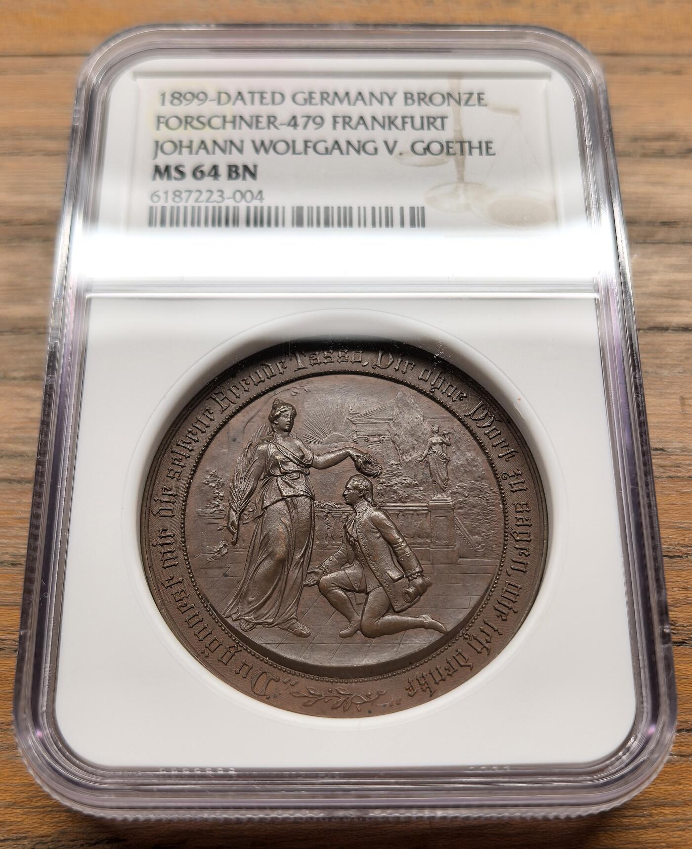 凡希社世界钱币微拍第三百二十一期 1899德国歌德诞辰150周年纪念铜章NGC-MS64，正面浮雕为拟人化的“诗歌女神”为歌德加冕的场景，环刻德语诗句“Nur die Sehnsucht bleibt, die ohne Dauer eilt”（唯有渴望永恒疾驰），背面雕刻歌德法兰克福出生地建筑实景。