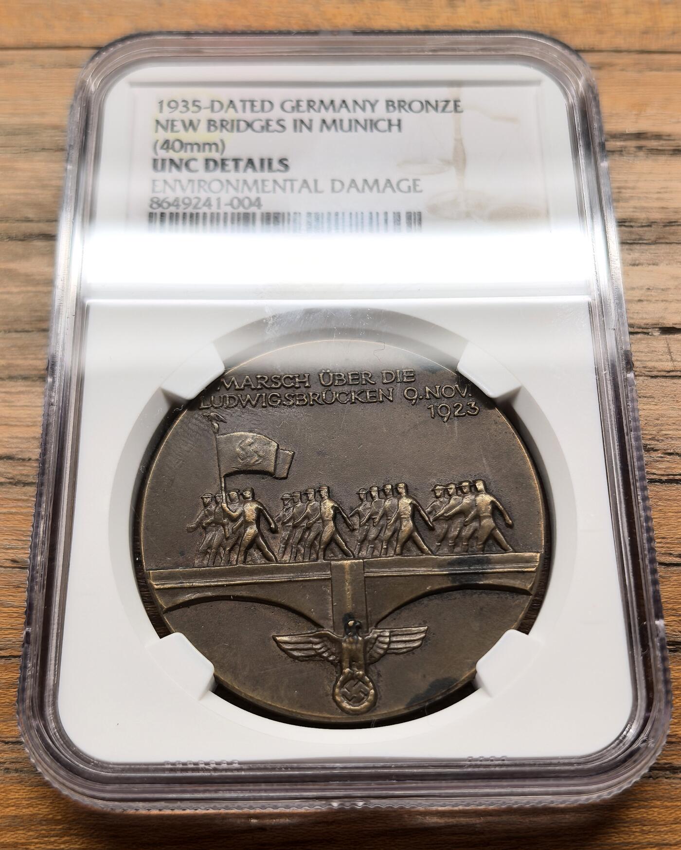 凡希社世界钱币微拍第三百二十一期 1935德国慕尼黑路德维希新桥落成纪念铜章NGC-UNCD，关联1923年11月9日慕尼黑啤酒馆暴动中纳粹分子跨越路德维希桥的事件，路德维希桥是慕尼黑伊萨尔河上的重要桥梁，1934年拆除旧桥后于1935年完成重建，成为当时慕尼黑城市建设与纳粹政治宣传的结合点。