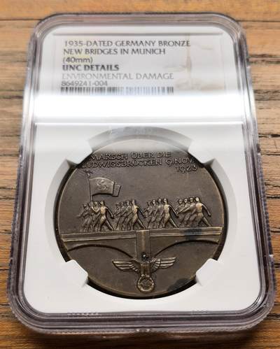 凡希社世界钱币微拍第三百二十一期 - 1935德国慕尼黑路德维希新桥落成纪念铜章NGC-UNCD，关联1923年11月9日慕尼黑啤酒馆暴动中纳粹分子跨越路德维希桥的事件，路德维希桥是慕尼黑伊萨尔河上的重要桥梁，1934年拆除旧桥后于1935年完成重建，成为当时慕尼黑城市建设与纳粹政治宣传的结合点。