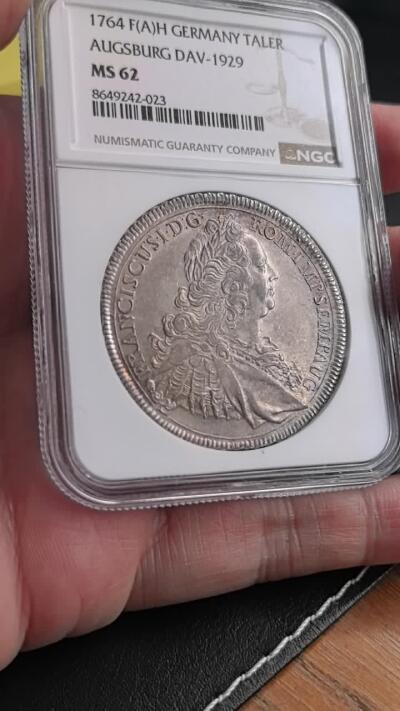 凡希社世界钱币微拍第三百二十一期 荐！1764神罗奥格斯堡弗朗茨一世戎装像泰勒大银NGC-MS62，1764年F(A)H版为奥格斯堡泰勒银币的末期发行版，弗朗茨一世次年去世，该币成为其在位时期的收官币种，铸造量远少于前期版本，也是神罗晚期钱币的代表性藏品。实物通体呈淡紫金彩，质感光泽美不胜收。（视频参考）