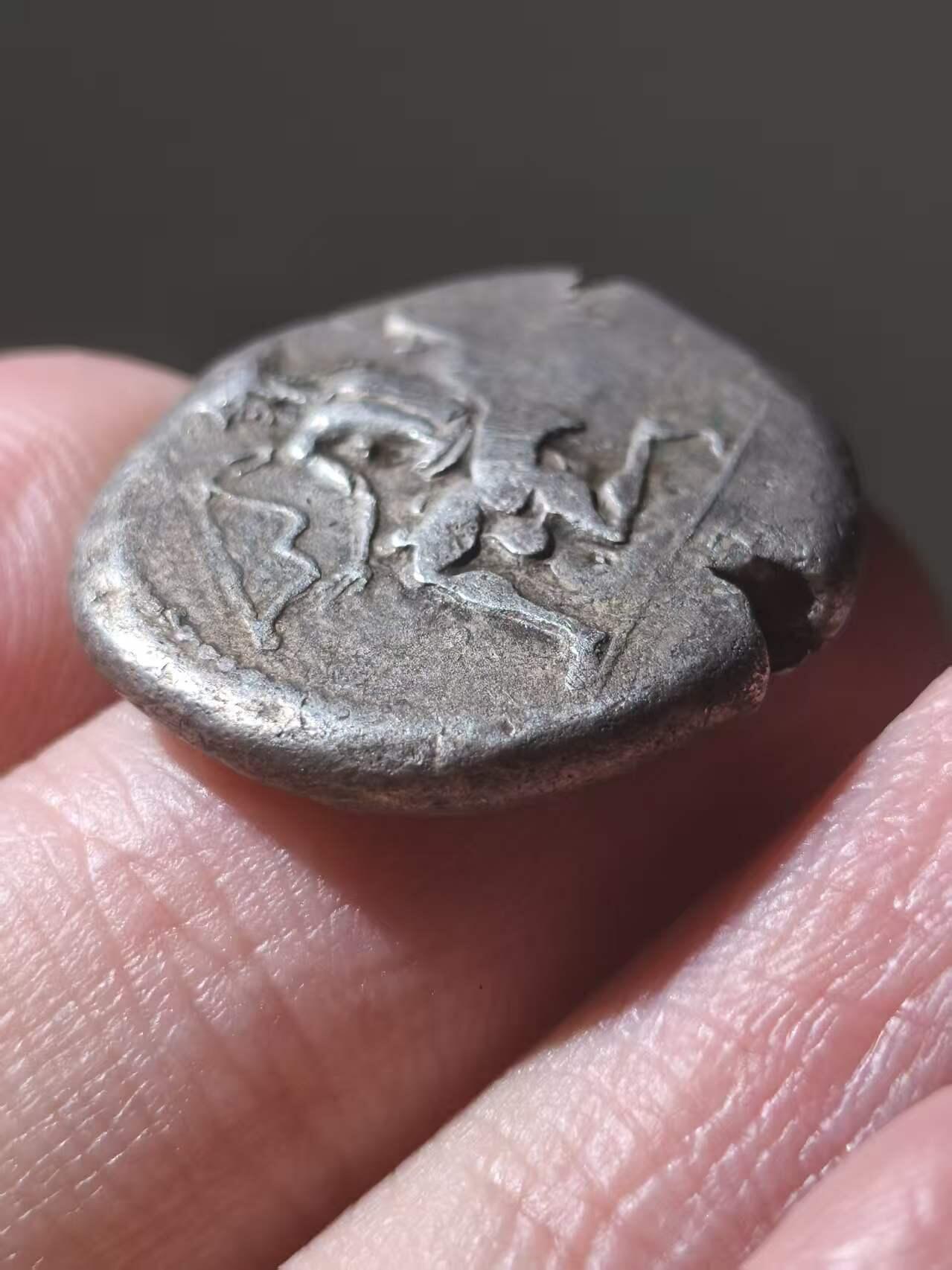 星盘世界钱币拍卖 古典时期- 古希腊 索洛伊斯塔特厚重大银币 约公元前440-410年。正面：亚马逊女战士跪于左侧，箭筒和弓袋置于身侧，手持弓箭；左侧有常春藤叶，右侧有头盔。背面：葡萄串；左侧有“ΣOΛEΩN”字样，有一些验银痕