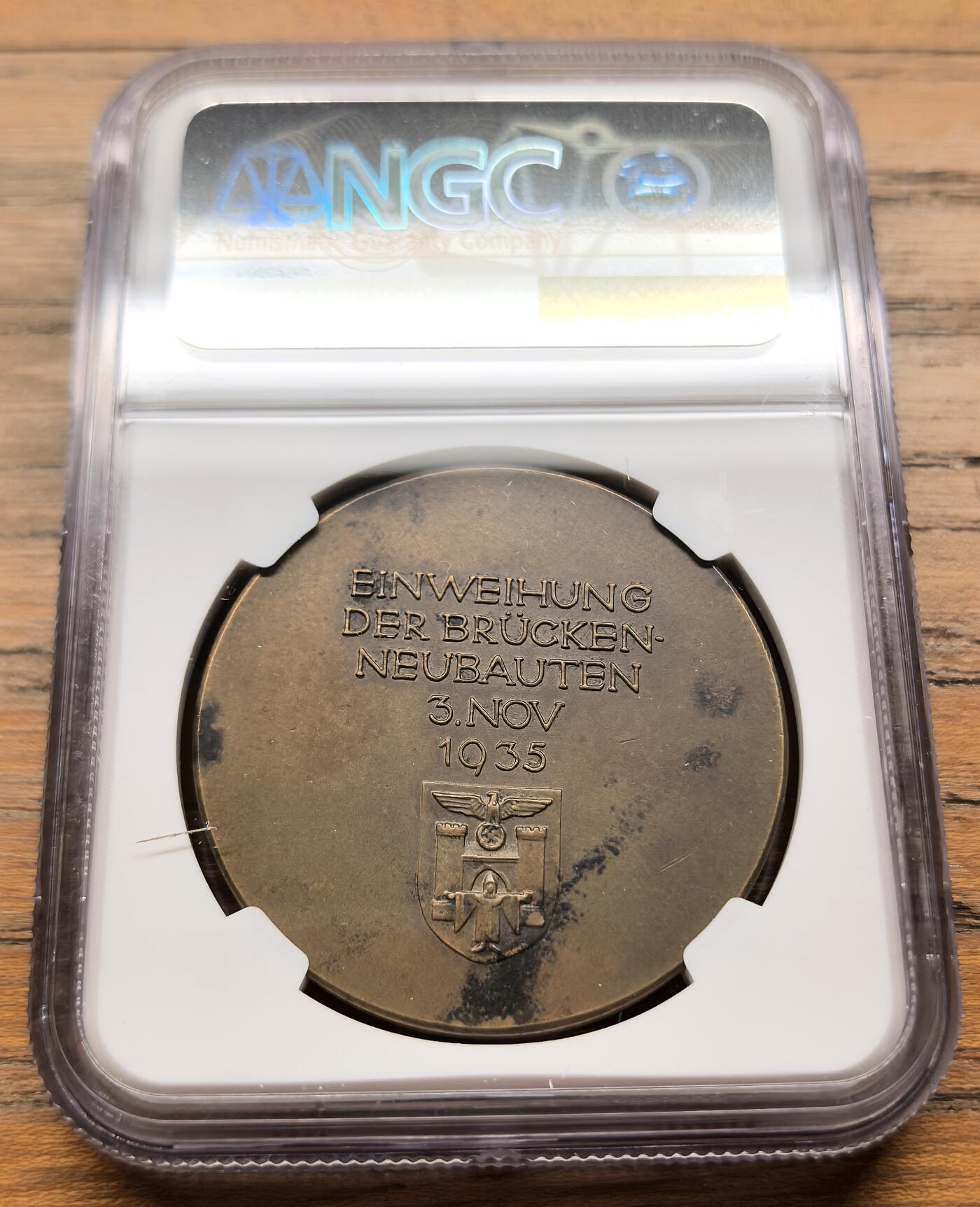 凡希社世界钱币微拍第三百二十一期 1935德国慕尼黑路德维希新桥落成纪念铜章NGC-UNCD，关联1923年11月9日慕尼黑啤酒馆暴动中纳粹分子跨越路德维希桥的事件，路德维希桥是慕尼黑伊萨尔河上的重要桥梁，1934年拆除旧桥后于1935年完成重建，成为当时慕尼黑城市建设与纳粹政治宣传的结合点。