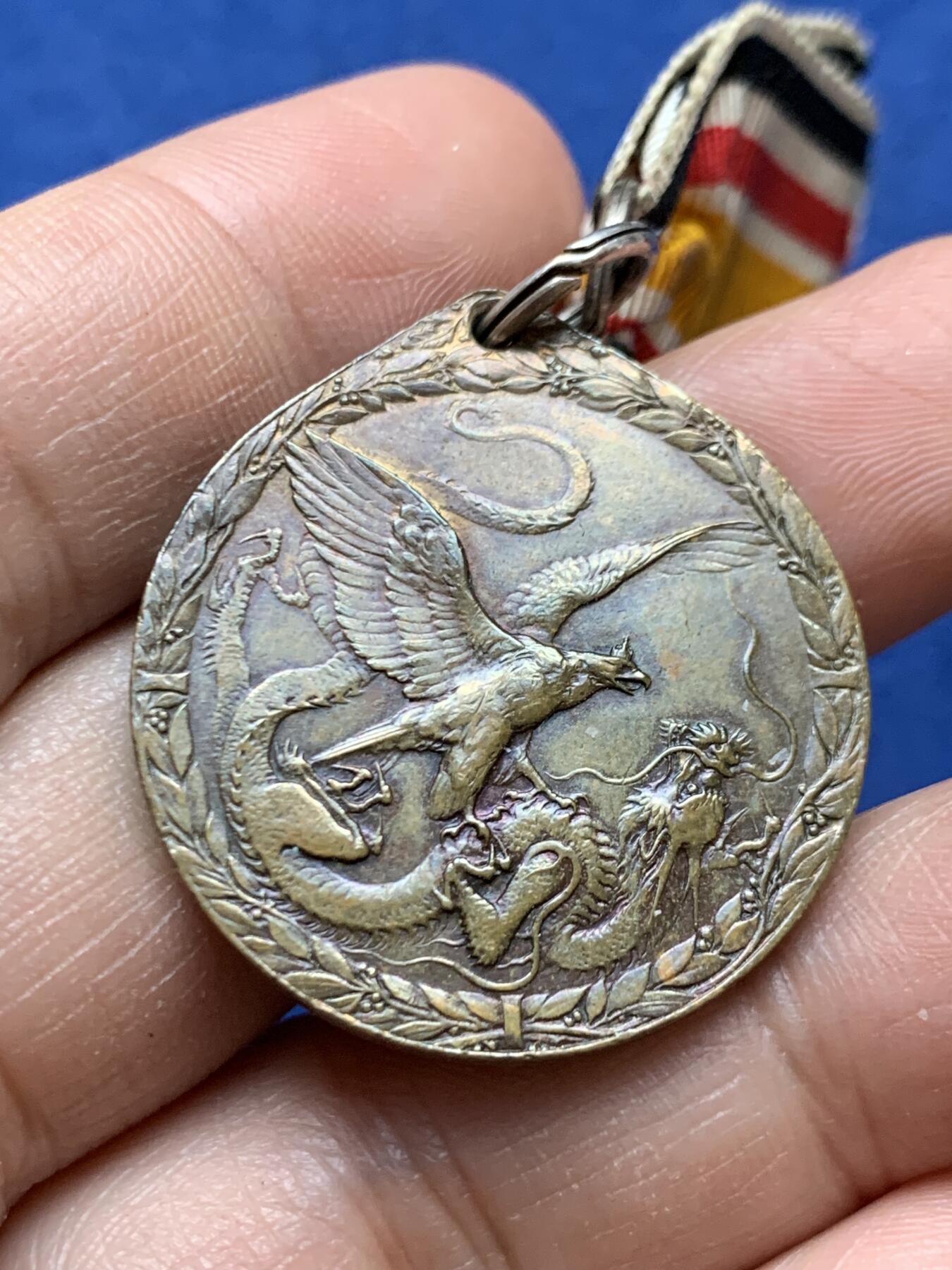 《竞宝斋》第470场 周日，周一，周二 3场连拍 （全场包邮）欢迎送拍 德国1900庚子事变龙鹰勋章，非常著名的品种。PCGS目前给进行评级，细节漂亮，背面有胶水残留，细节见图，总重17.6克。