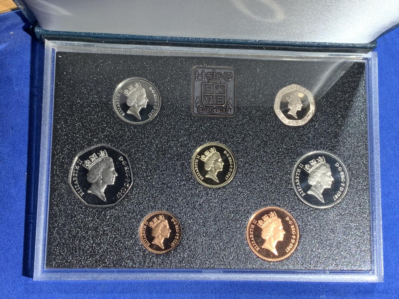 《竞宝斋》第470场 周日，周一，周二 3场连拍 （全场包邮）欢迎送拍 英国1987年精制套币，带1枚1英镑橡树精制纪念币，7枚币，盒证齐全，品相精美，蓝色盒装。