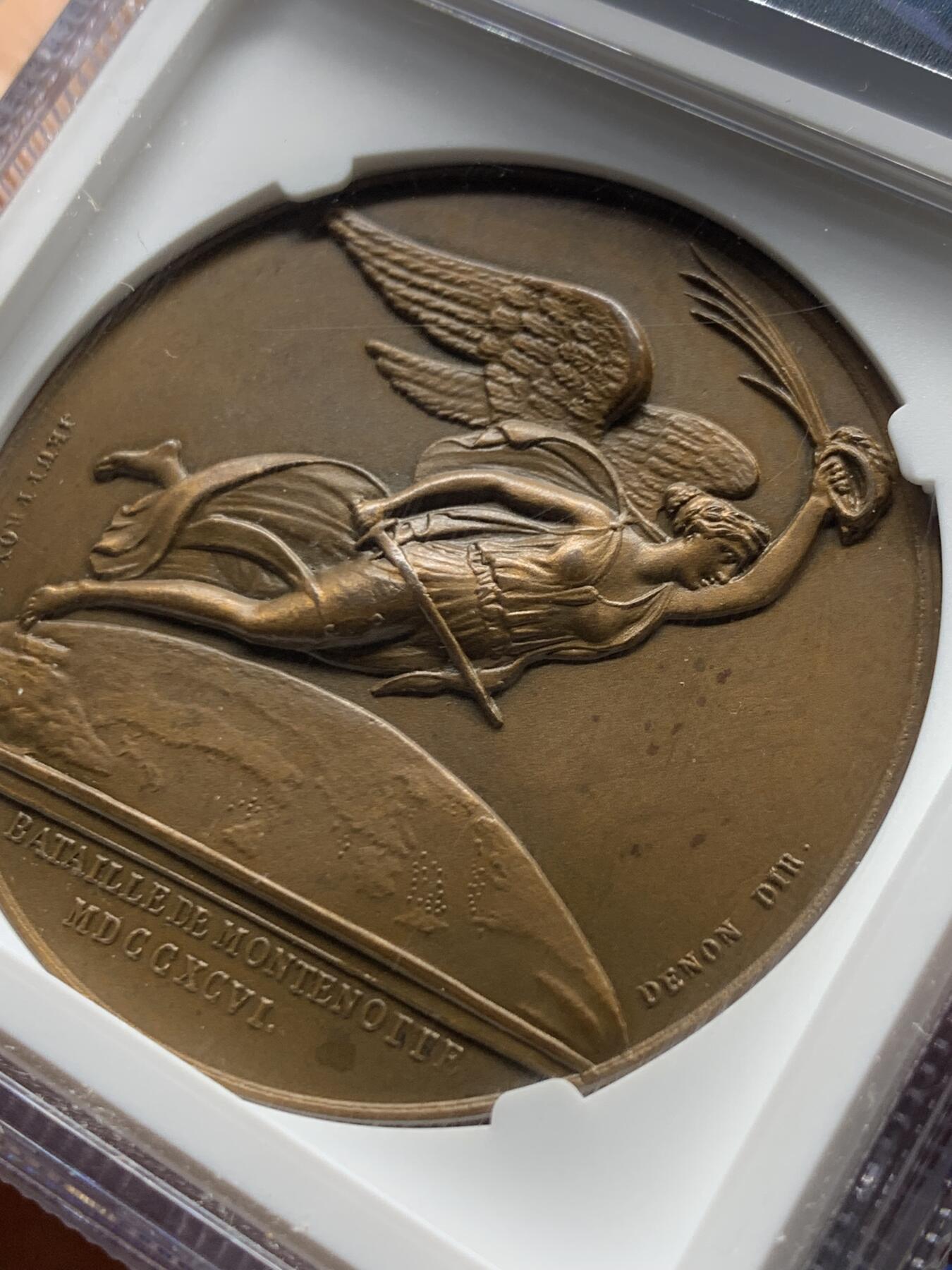 《竞宝斋》第470场 周日，周一，周二 3场连拍 （全场包邮）欢迎送拍 NGC MS63BN 法国1796年拿破仑蒙特诺特之战铜章  第一执政长发飘逸稀少头像版本 背面持剑胜利女神飞跃地中海上空 羽毛和衣物刻画飘逸 天马行空的勾划 加厚盒装 丰饶角边铭