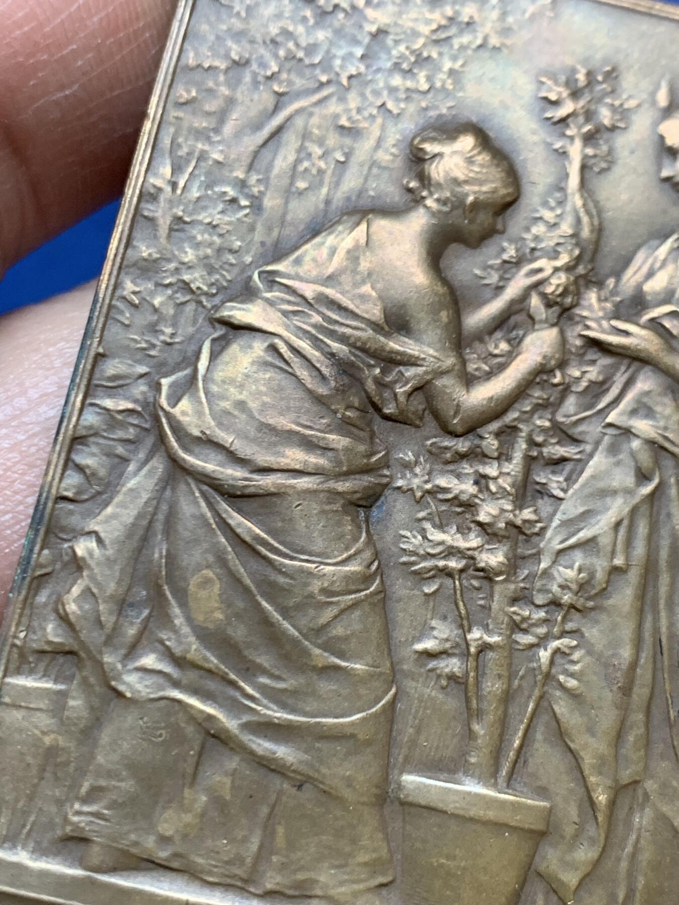 《竞宝斋》第470场 周日，周一，周二 3场连拍 （全场包邮）欢迎送拍 法国1892年园艺女神矩形大铜章，79.4克，61.5x48.5mm，大师Dupuis名作，Maier章牌目录122号。Dupuis也是名章“泉”“巢”系列的作者。双女神研究园艺种植，画面生动细致。铜光泛彩，状态上佳。