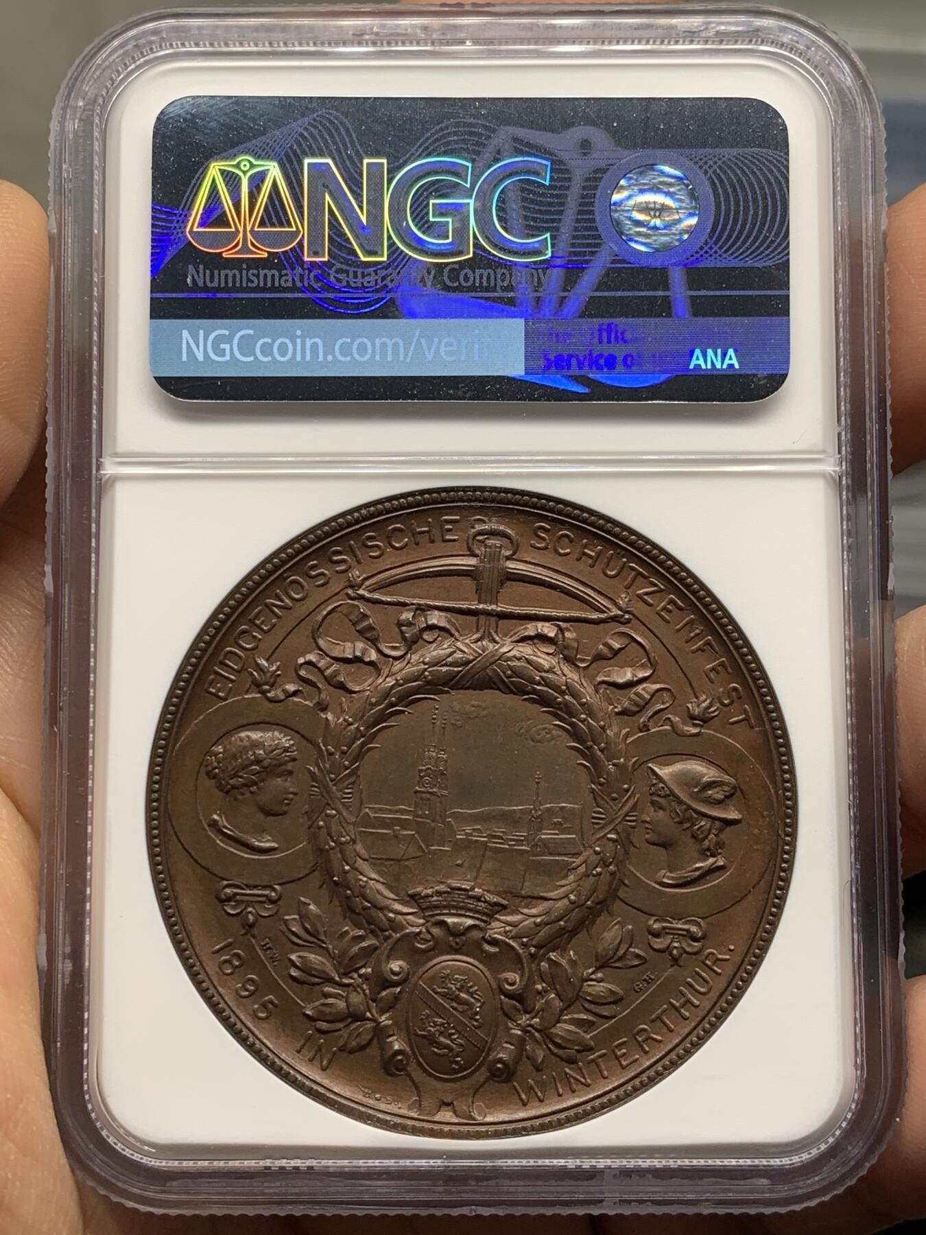 《竞宝斋》第471场 周日，周一，周二 3场连拍 （全场包邮）欢迎送拍 NGC MS64BN 瑞士1895年景观大铜章，正面女神捧花，背面市景和双人物头像，高浮雕设计，丝滑巧克力。