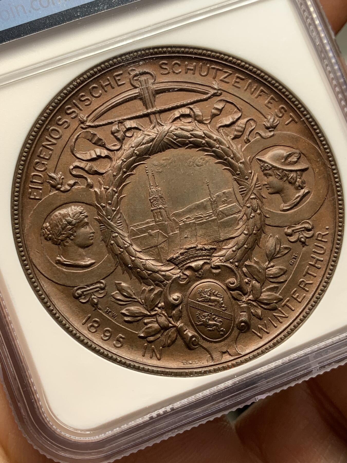 《竞宝斋》第471场 周日，周一，周二 3场连拍 （全场包邮）欢迎送拍 NGC MS64BN 瑞士1895年景观大铜章，正面女神捧花，背面市景和双人物头像，高浮雕设计，丝滑巧克力。