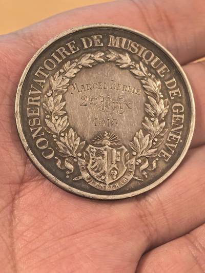 欧洲银章、铜章，大优惠起拍价都是银价计算 日内瓦音乐学院银质纪念银章34.2克 这是一枚来自瑞士日内瓦音乐学院（Conservatoire de Musique de Genève）的银质纪念章，是为了表彰1915年的优秀学生Marcel Blouin而颁发的。 正面（Avers）二等奖