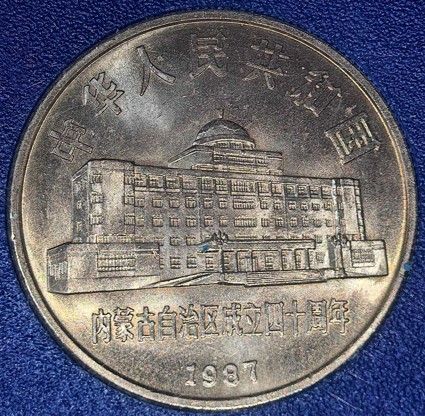 1987年内蒙古自治区成立四十周年纪念币，中国人民银行原装盒币，带蒙文说明。正面人大办公楼，背面放牧图+蒙文，面值1元，铜质，收藏佳选，按图发货！