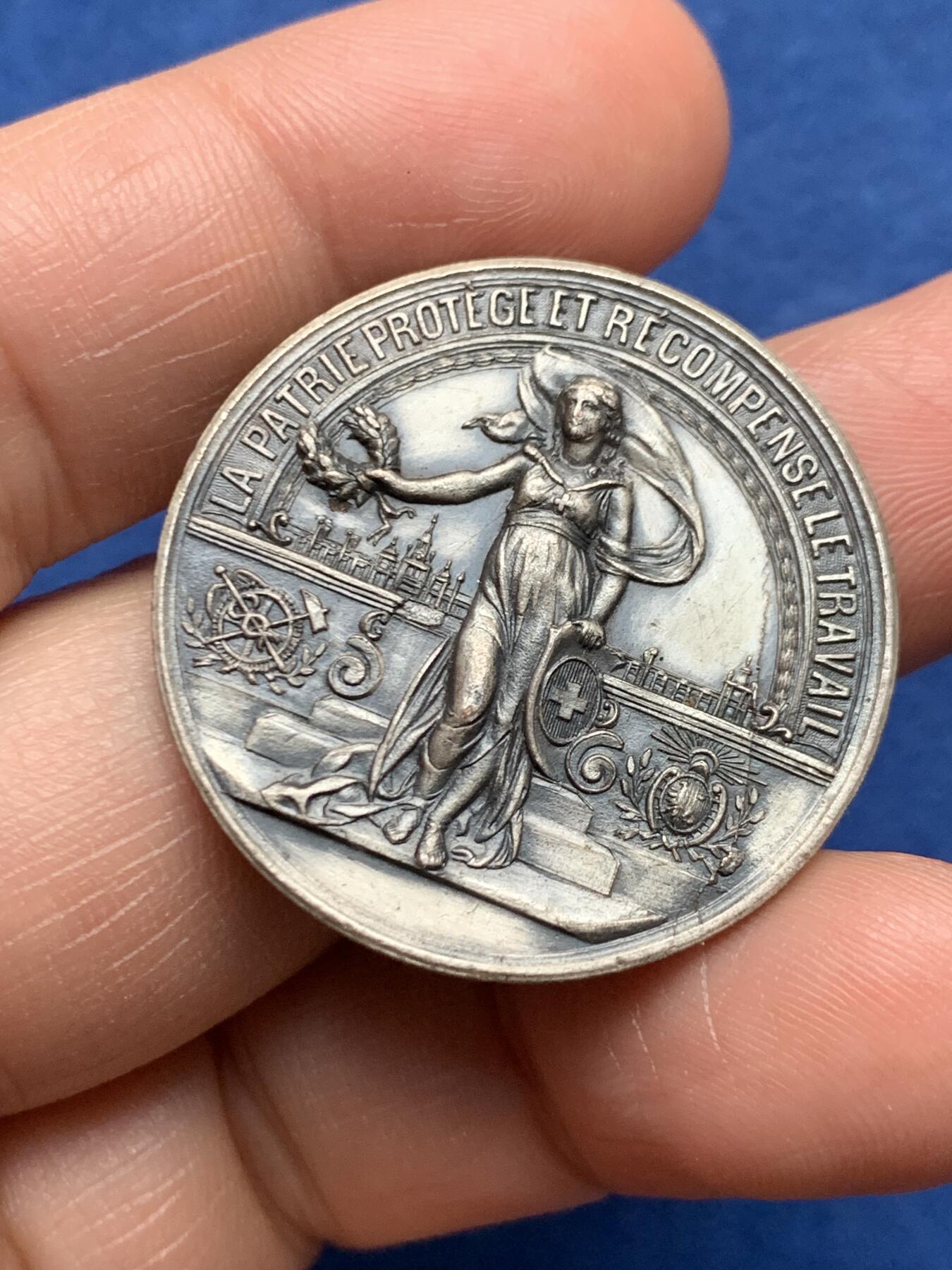 《竞宝斋》第472场 周日，周一，周二 3场连拍 （全场包邮）欢迎送拍 瑞士日内瓦全国博览会纪念章，主题为“祖国保护并奖励劳动”，是瑞士工业与爱国主题的经典章牌，单面品种，背面有去固定痕迹。14.7克，33.1mm。