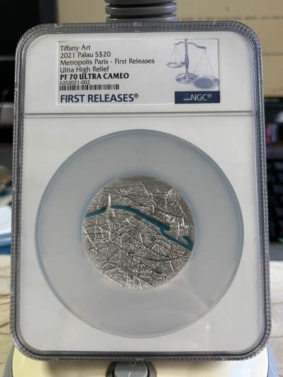 第193期拍卖 - 2021 年帕劳 “都市巴黎” 超高浮雕银币，NGC PF70 Ultra Cameo（首期发行）评级，面值 20 元，采用 Ultra High Relief 超高浮雕工艺，币面以立体微雕呈现巴黎城市肌理与塞纳河蓝色珐琅镶嵌，工艺极具视觉冲击力。999银，3盎司，发行999枚