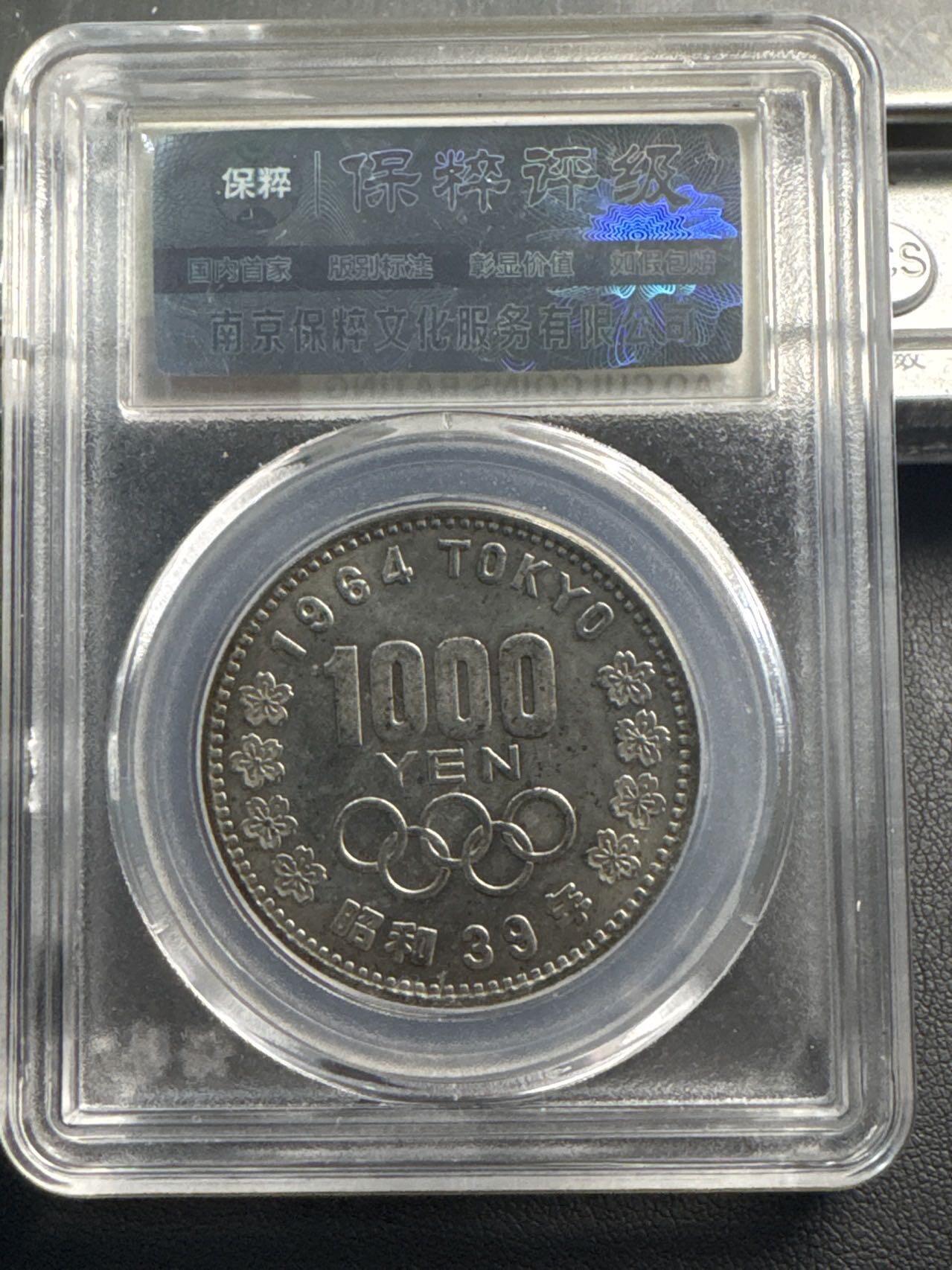 ❤️【币观天下】❤️ 第345期钱币拍卖场- 2026.3.20周五晚上6点半场 长期征集拍品  1964年日本大奥1000元银币，20克925银，评分AU58
