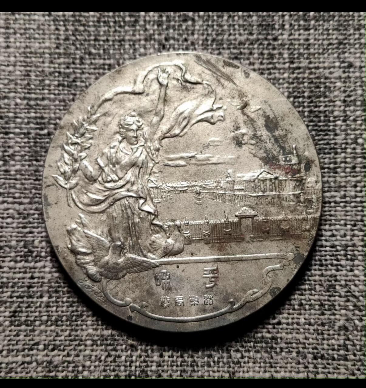 百年历史：自然百年氧化）巴黎和会纪念银章  保养的非常好！（没有任何翻新和清洗）  日本以1919年巴黎和会为主题，特别是凡尔赛条约的签订。银章尺寸为55mm，重量94.5g，银成色90%，由饭田仁三郎、佐藤磐分别设计。