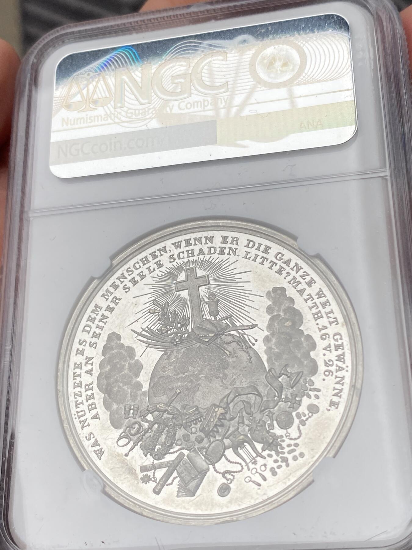 万国钱币拍卖第063期 NGC MS62 19世纪德国坚信礼圣母玛利亚纪念锡章 深度镜面精铸浮雕喷砂质感 锡制章牌出分极其不易 圣母形象刻画极其生动 背面天主十字架插在地球之上 下面是各类宝物代表财富