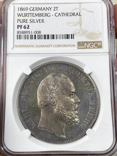 万国钱币拍卖第063期 - NGC PF62 1869年德国符腾堡乌尔姆大教堂精制纯银2泰勒 999纯银版 仅制作了80枚作为王公贵族的礼物发放 由于纯银材质较软 保存极为不易 此等原味五彩状态可谓凤毛麟角 玫瑰色的包浆洒落在镜面底板之上 世界最高的乌尔姆大教堂融入方寸之间 成为德式精工最好的诠释 如今一枚好品普通版本教堂已是相当有难度的存在 更不用说是1/80的1869纯银 真正的稀缺资源 顶级德邦2泰勒藏品