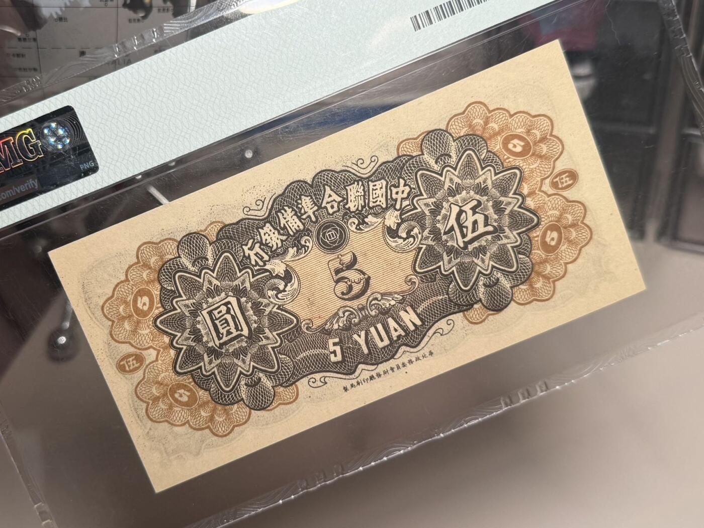 【乾奕收藏】出民国33年1944年中国联合准备银行伍圆，水印版，行标水印，右岳飞蟒袍捧书图案，美国PMG58分，油墨浓郁，图案清晰，同分数中状态较为出色的一枚，民国纸币经过80年能保存如此品相实属难得，喜欢的老板不要错过，评级币一切以分数为准，售出非假不退