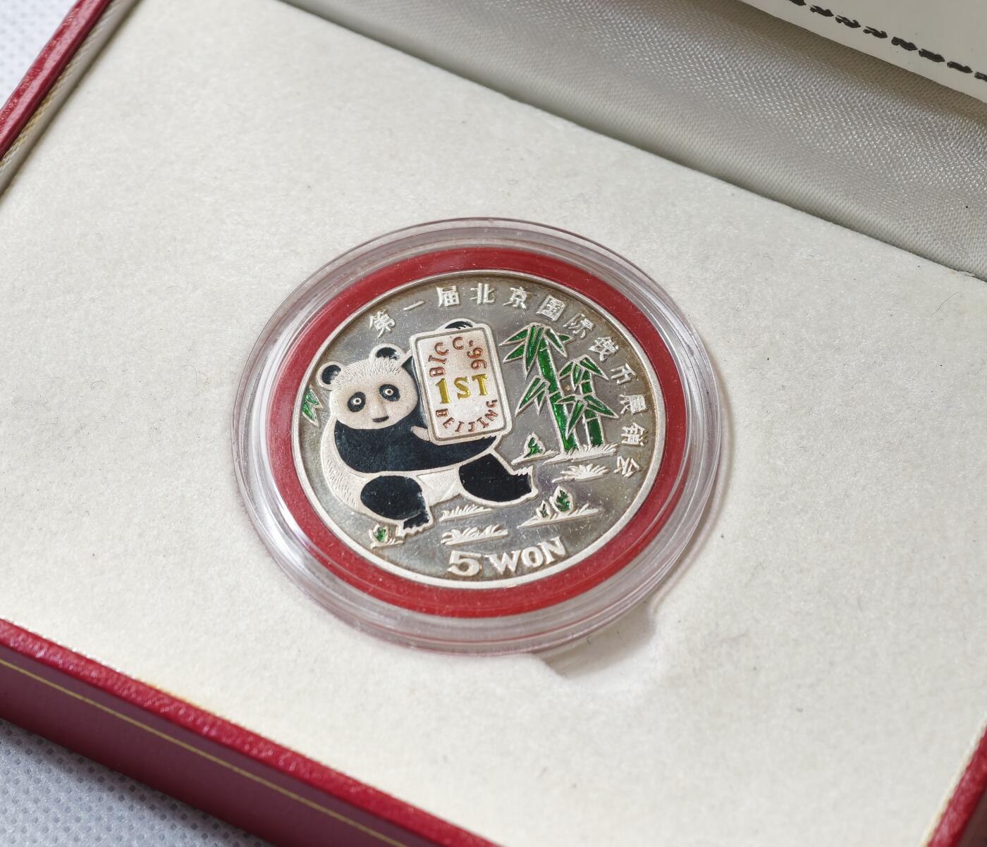 甄臻铺-世界币章拍卖（第55期），3月28日甄品场（直播拍卖）拍品征集中，送拍享返佣金等优惠多多 1996年朝鲜参加首届北京国际钱币展特别发行彩色熊猫币，仅发行6000枚，当年现场发售少部分，其余回流朝鲜，市场罕见，老精稀品种，盒证齐全