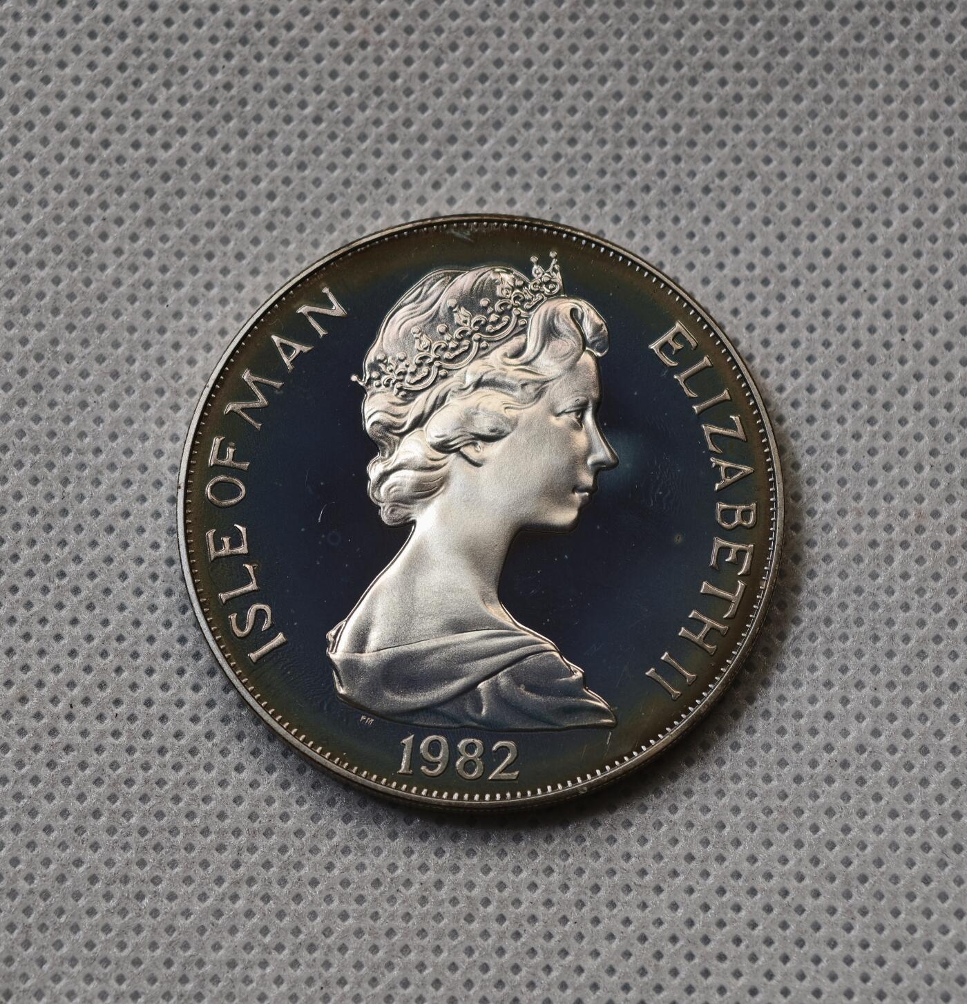 甄臻铺-世界币章拍卖（第55期），3月28日甄品场（直播拍卖）拍品征集中，送拍享返佣金等优惠多多 1982年马恩岛1克朗精制银币，FIFA世界杯主题，预热品种，发行量1.5万枚，28.5克925银