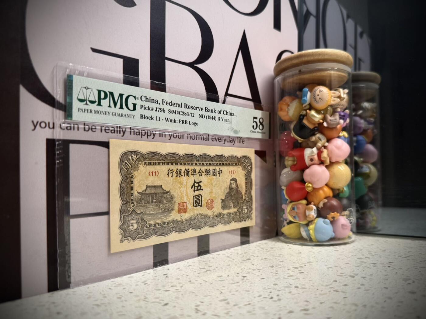 【乾奕收藏】出民国33年1944年中国联合准备银行伍圆，水印版，行标水印，右岳飞蟒袍捧书图案，美国PMG58分，油墨浓郁，图案清晰，同分数中状态较为出色的一枚，民国纸币经过80年能保存如此品相实属难得，喜欢的老板不要错过，评级币一切以分数为准，售出非假不退