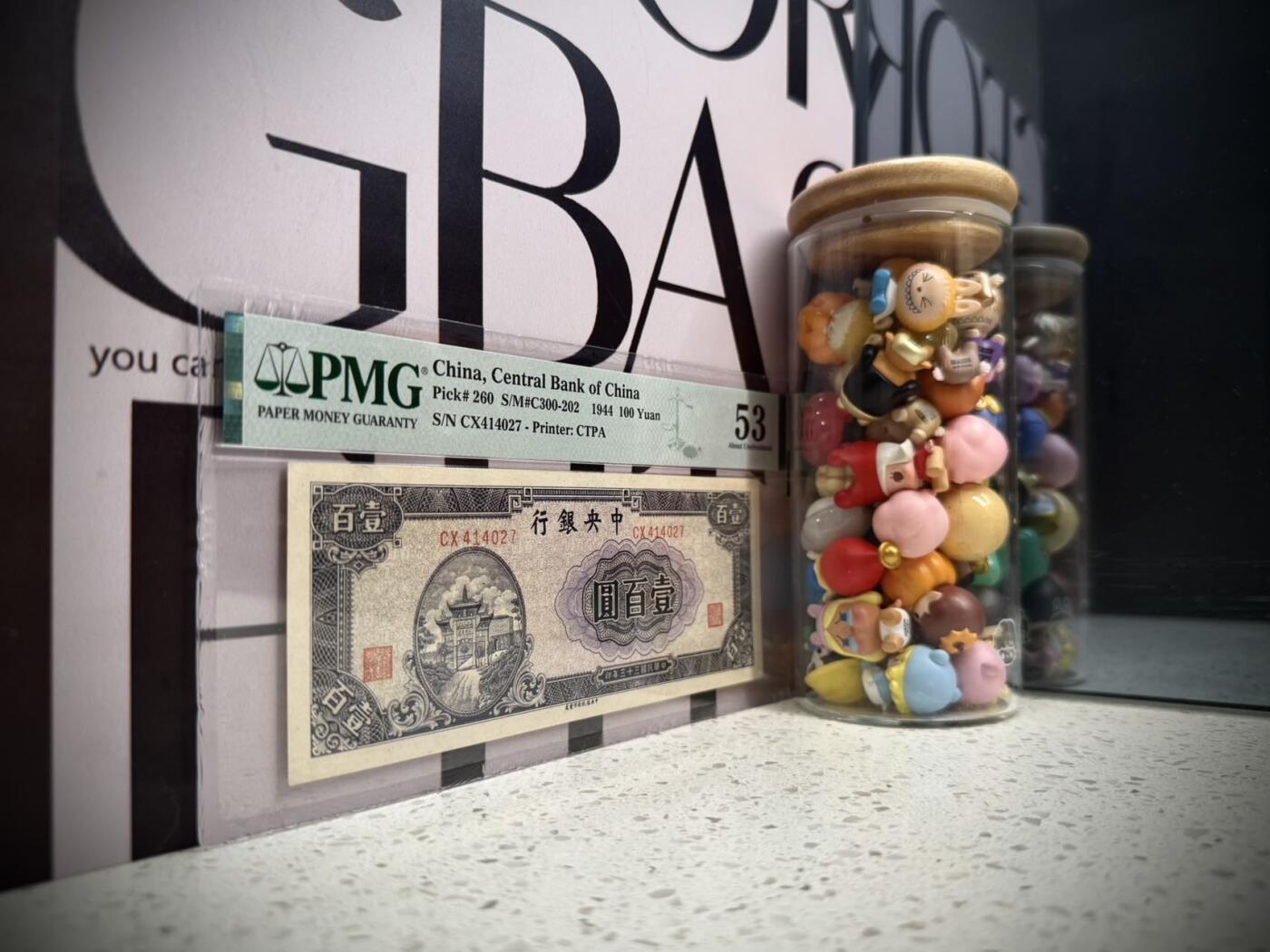 （自动截拍）PMG评级民国纸币专拍第20260323期，全场包邮 【乾奕收藏】出民国33年1944年中央银行信托版壹佰圆，美国PMG53分，复兴关牌坊图案