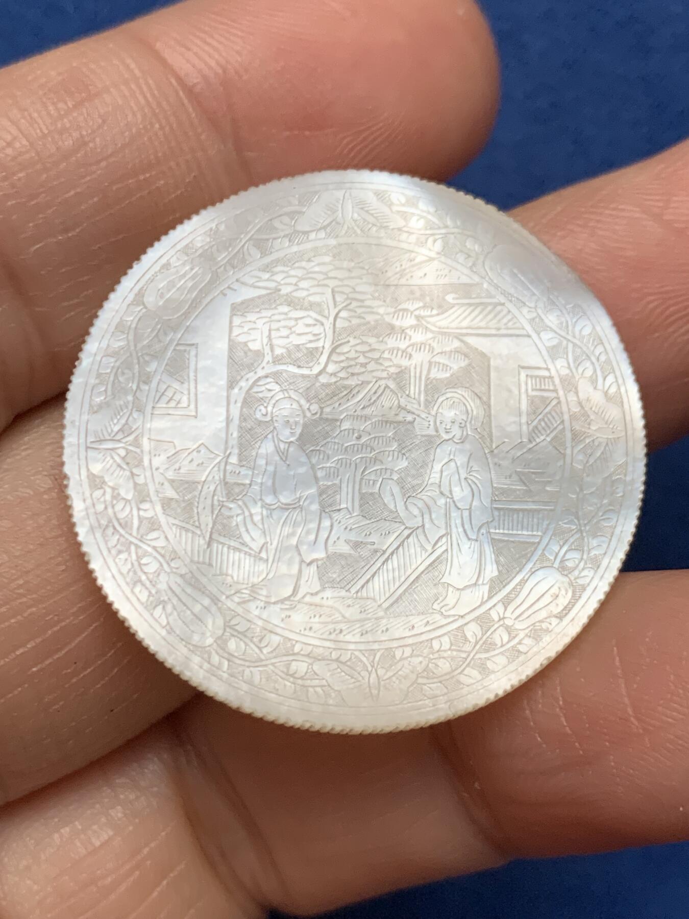 《竞宝斋》第473场 周日，周一 2场连拍 （全场包邮）欢迎送拍 英国一线回流清螺钿贝母筹码或代币一枚。手工精雕，中式园林公子仕女图，蝶花纹路看可能是梁祝。莹光宝气，少见厚片圆形款，侧边有齿。