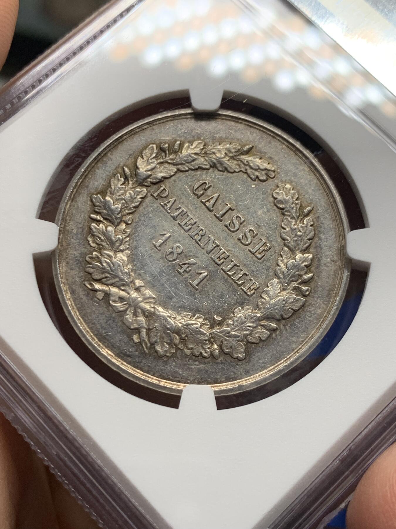 《竞宝斋》第473场 周日，周一 2场连拍 （全场包邮）欢迎送拍 NGC MS61 法国“父爱储蓄基金”银质八角代币，该币正面图案为一座茅草屋顶的小屋，象征家庭与储蓄，周围环绕星星与装饰纹样，寓意“父爱”与“守护”。