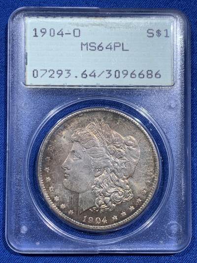 《竞宝斋》第473场 周日，周一 2场连拍 （全场包邮）欢迎送拍 - PCGS MS64PL 美国1904-O 摩根1美元大银币，绝版初代P盒，盒子历史就已近40年。 PL大多是白币，彩币出PL极难，此枚绚丽五彩+PL镜面+绝版盒，真正藏家品质，摇摇乐不可多得的品种