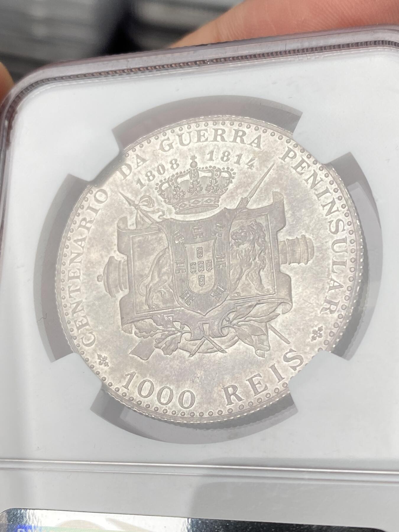 万国钱币拍卖第063期 NGC PF64 1910年葡萄牙艾曼纽尔二世半岛战争百年纪念1000瑞斯大银 正面为葡萄牙末代国王艾曼纽尔二世 背面雄狮护盾 一门火炮穿插其中 尽显王者风范 镜面底板在紫罗兰五彩的加持下光彩夺目 实物上手惊艳 葡萄牙任何精制币都极其罕见 大银主币更是难得 此枚NP评级记录均为个位数 错过难再的顶级葡系藏品 HA一月64CAM成交价约合人民币6万元