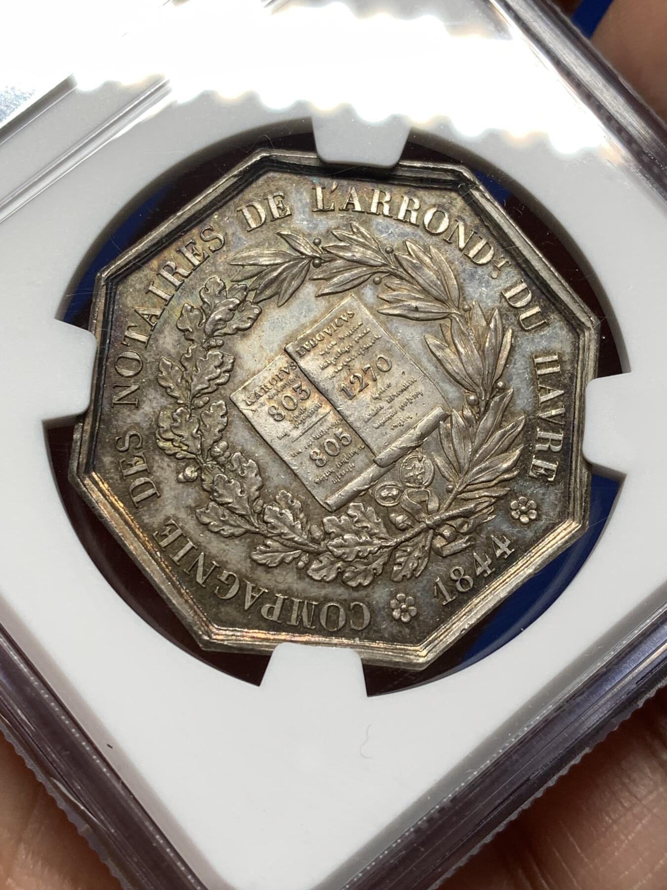 《竞宝斋》第474场 周日，周一 2场连拍 （全场包邮）欢迎送拍 NGC MS62 法国1844年勒阿弗尔公证人银质八角代币，手指铭，少见款。正面：双国王头像（圣路易与查理曼大帝），外环文字象征公证行业权威，背面：中央法典图案，外环“勒阿弗尔区公证人公司”，下方年份“1844”，周围橡叶与月桂叶花环。