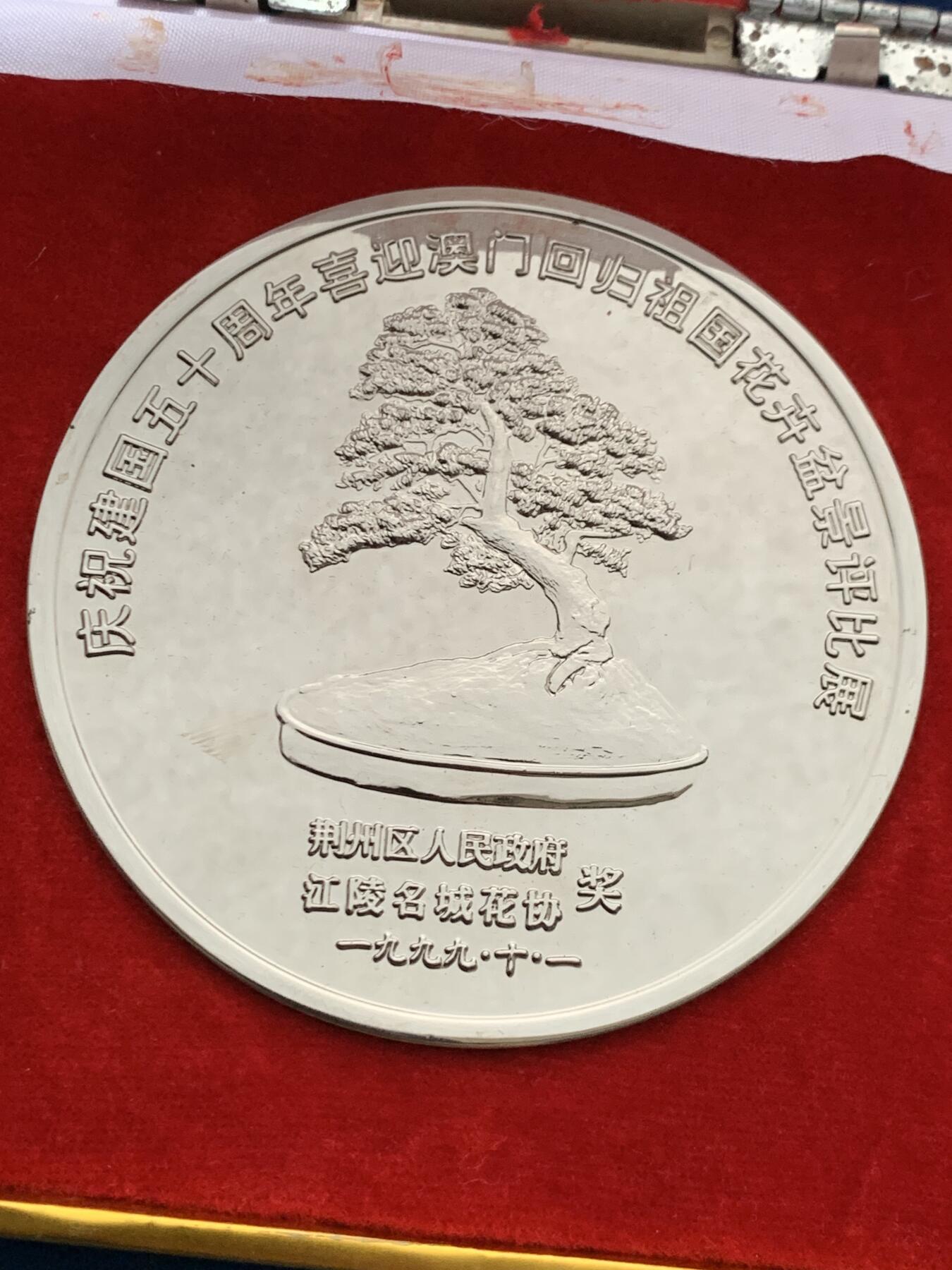 《竞宝斋》第474场 周日，周一 2场连拍 （全场包邮）欢迎送拍 1999年庆祝澳门回国荆州花卉盆景展纪念奖章，铜章电镀，220.7克，直径79.2mm，面积大，沉手，设计制作精美，保存较好，有原盒，盒子有破损，少见。