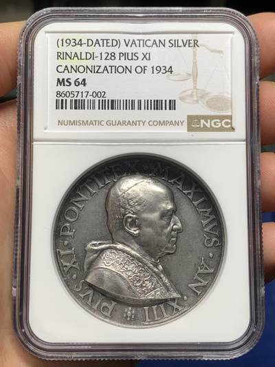 《竞宝斋》第474场 周日，周一 2场连拍 （全场包邮）欢迎送拍 - NGC MS64 高分，加厚盒，稀少品种。梵蒂冈教皇庇护十一世于1934年发行的银质纪念章，由雕刻师A.Mistruzzi设计，用于纪念七位圣人的封圣仪式。纪念章正面为教皇左侧半身像，身着教宗礼服；背面描绘七位圣人立于云上，背景有十字架，铭文为拉丁语意“神圣救赎之年圆满结束”。该章发行了稀少，极具收藏价值。