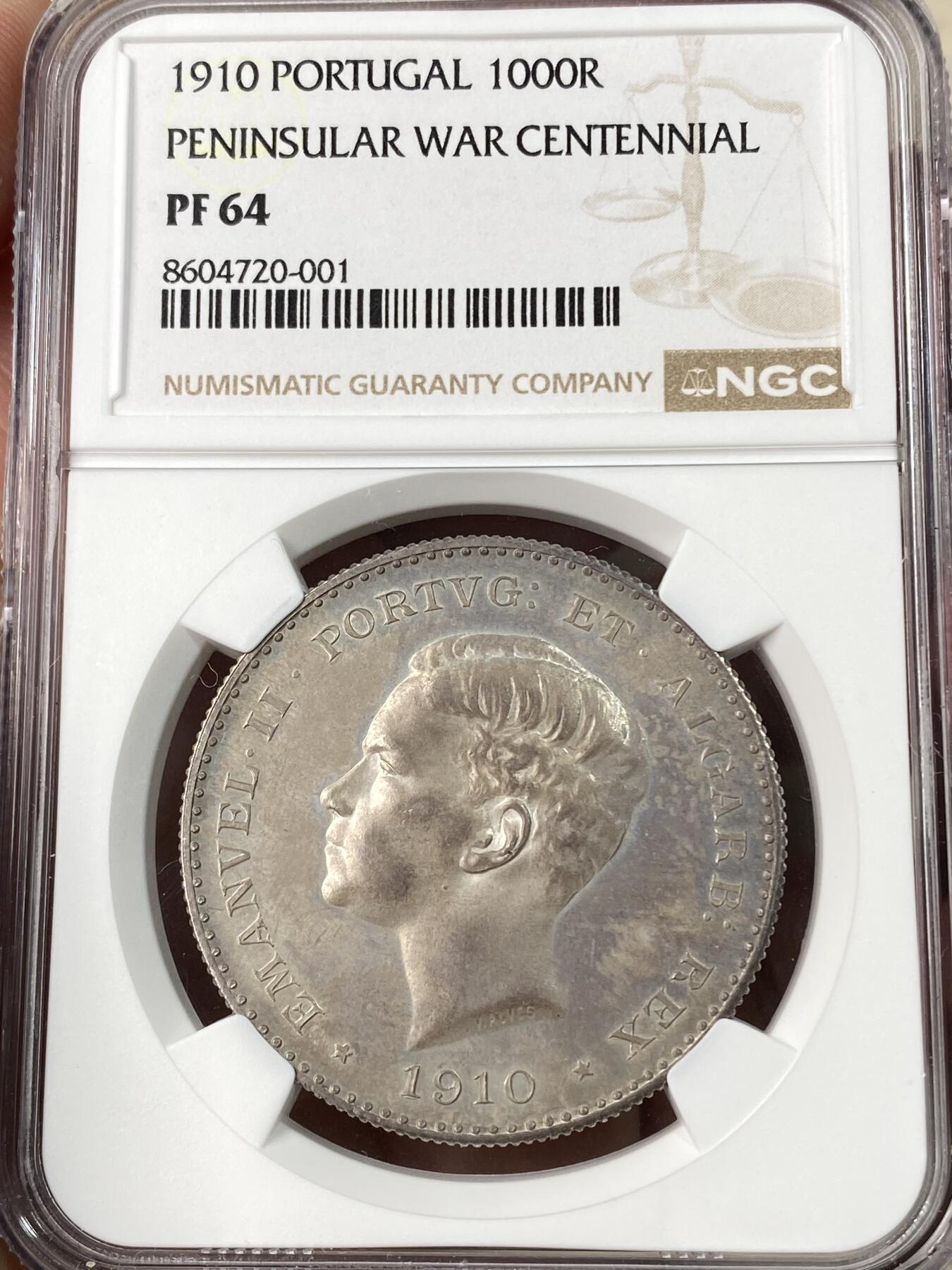 万国钱币拍卖第063期 NGC PF64 1910年葡萄牙艾曼纽尔二世半岛战争百年纪念1000瑞斯大银 正面为葡萄牙末代国王艾曼纽尔二世 背面雄狮护盾 一门火炮穿插其中 尽显王者风范 镜面底板在紫罗兰五彩的加持下光彩夺目 实物上手惊艳 葡萄牙任何精制币都极其罕见 大银主币更是难得 此枚NP评级记录均为个位数 错过难再的顶级葡系藏品 HA一月64CAM成交价约合人民币6万元