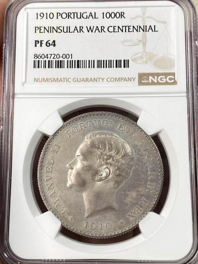 万国钱币拍卖第063期 - NGC PF64 1910年葡萄牙艾曼纽尔二世半岛战争百年纪念1000瑞斯大银 正面为葡萄牙末代国王艾曼纽尔二世 背面雄狮护盾 一门火炮穿插其中 尽显王者风范 镜面底板在紫罗兰五彩的加持下光彩夺目 实物上手惊艳 葡萄牙任何精制币都极其罕见 大银主币更是难得 此枚NP评级记录均为个位数 错过难再的顶级葡系藏品 HA一月64CAM成交价约合人民币6万元