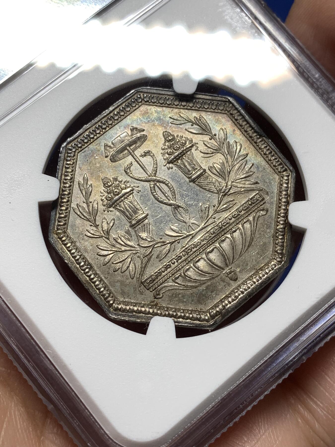 《竞宝斋》第474场 周日，周一 2场连拍 （全场包邮）欢迎送拍 NGC AU58 法国储蓄银行八角银质代币，早期无边铭，出分不易，少见款。正面：财富女神端坐，一旁的箱子里装满了财宝。