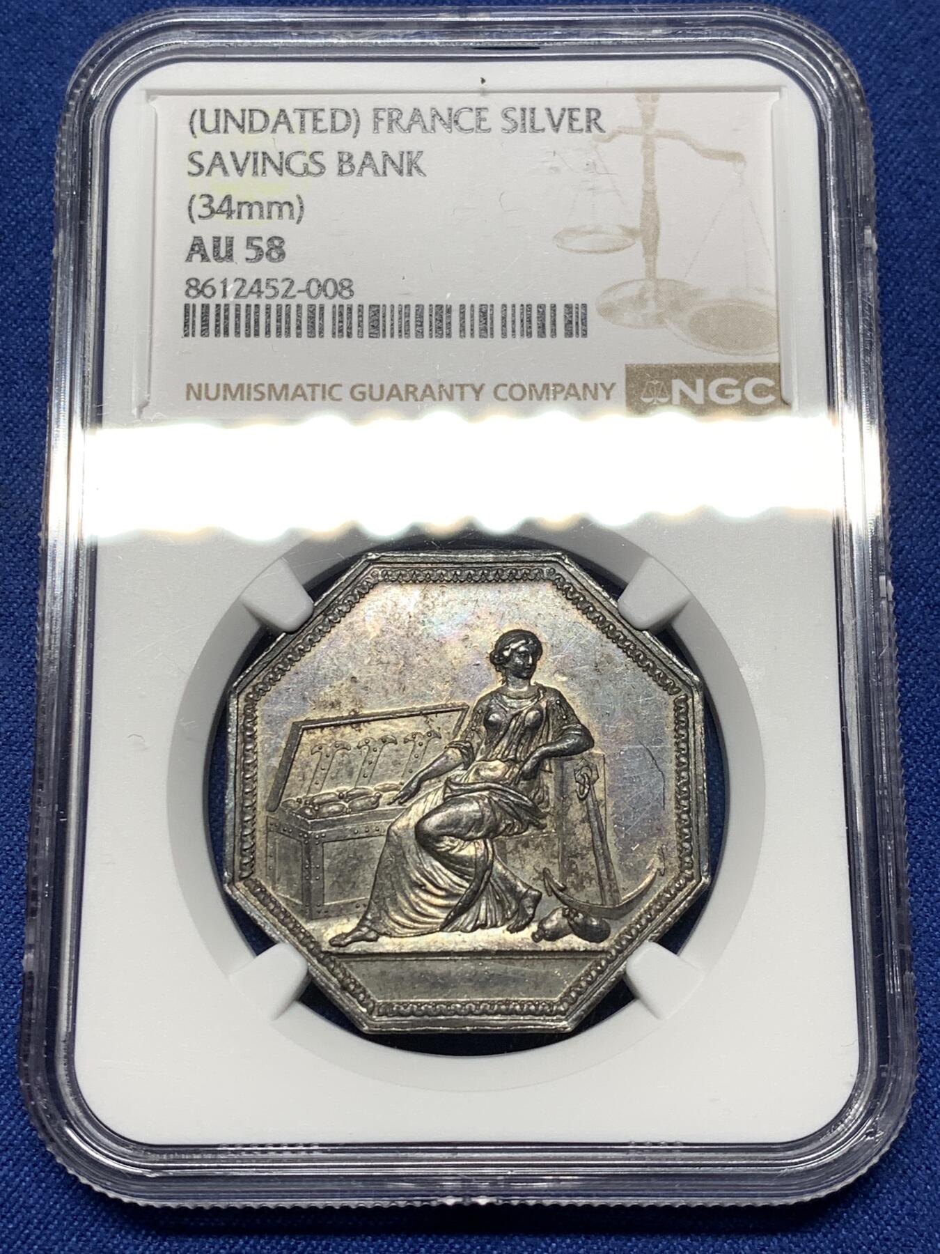 《竞宝斋》第474场 周日，周一 2场连拍 （全场包邮）欢迎送拍 NGC AU58 法国储蓄银行八角银质代币，早期无边铭，出分不易，少见款。正面：财富女神端坐，一旁的箱子里装满了财宝。