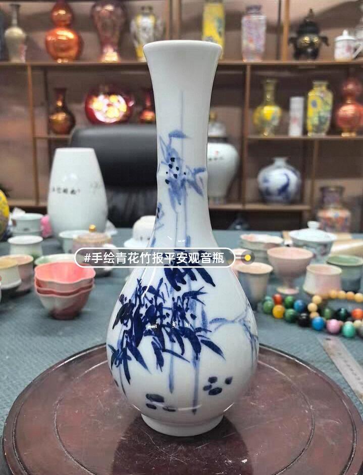 景德镇青花竹报平安花瓶，玉壶春造型，白瓷胎青花发色纯正，竹叶纹饰清新雅致。瓶身绘制竹叶纹饰，釉面莹润。无瑕疵，适合插花或家居摆件。 高约27厘米，口径5厘米，腹径11厘米