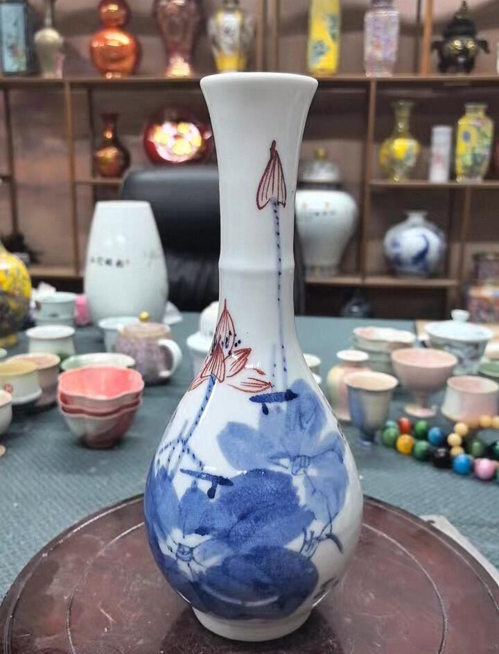 景德镇青花竹报平安花瓶，玉壶春造型，白瓷胎青花发色纯正，竹叶纹饰清新雅致。瓶身绘制竹叶纹饰，釉面莹润。无瑕疵，适合插花或家居摆件。 高约27厘米，口径5厘米，腹径11厘米