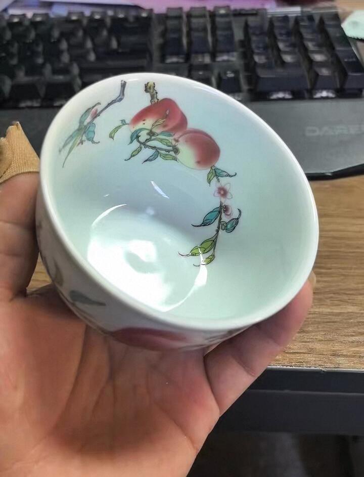 景德镇粉彩寿桃主人杯，全新未使用，纯手工绘制，画面精美，寓意福寿安康。底部有“景德镇珍藏”款识，陶瓷材质，手感细腻，收藏或日常品茶都很合适。  杯高约6厘米，口径约9厘米，容量约100毫升。