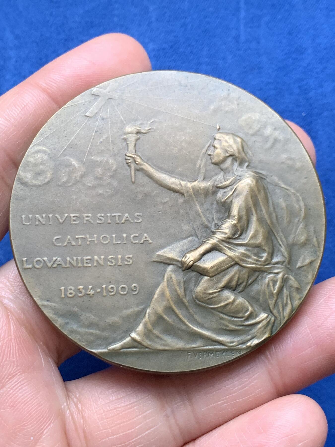 《竞宝斋》第474场 周日，周一 2场连拍 （全场包邮）欢迎送拍 1834年至1909年天主教鲁汶大学发展历程纪念大铜章，铭文“UNIVERSITAS CATHOLICA LOVANIENSIS 1834-1909”，正面是一位象征知识与光明身披长袍的女神手持火炬。著名雕刻家：Devreese设计雕刻，直径：59.7mm，重：136.4g。