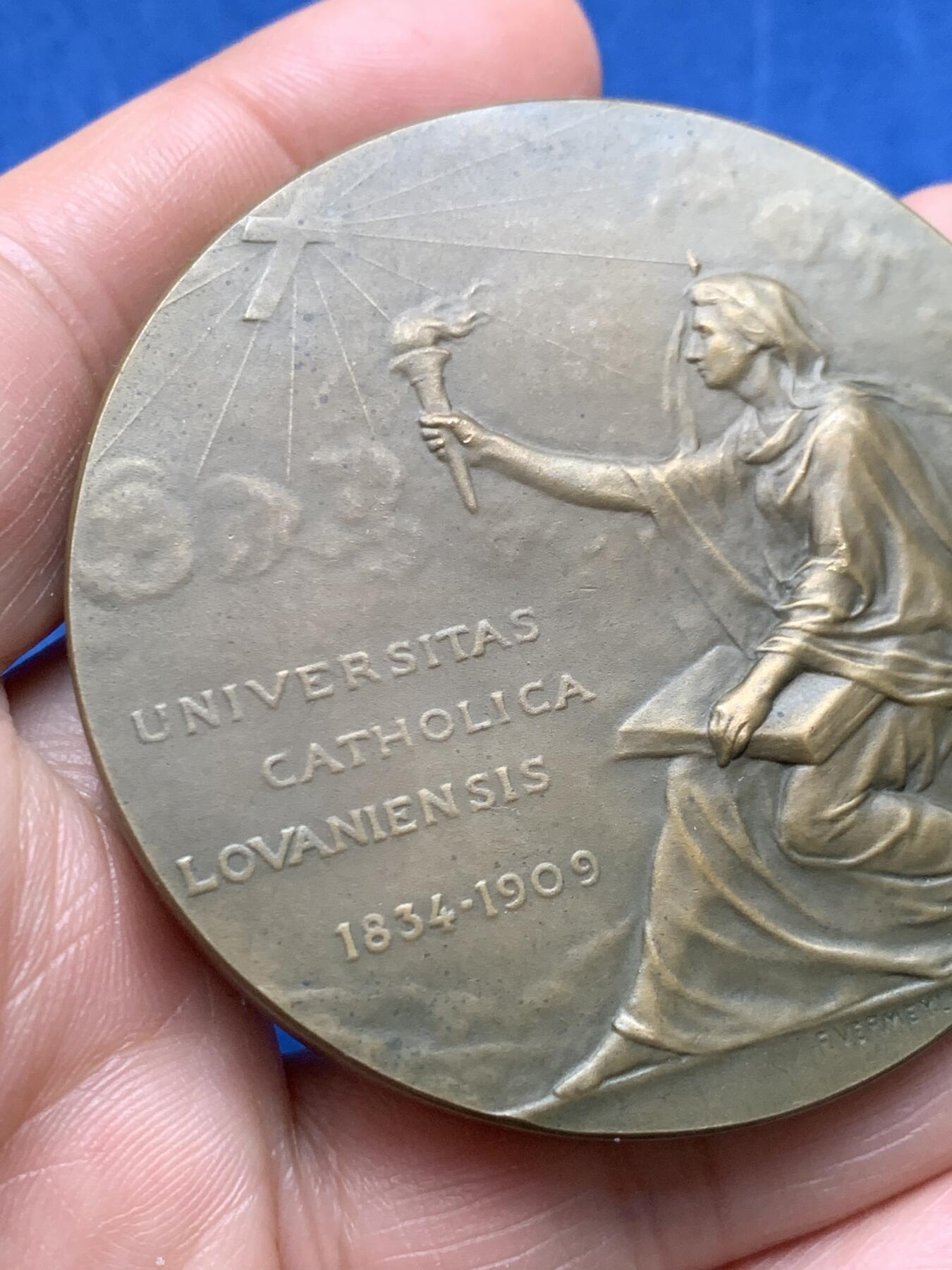 《竞宝斋》第474场 周日，周一 2场连拍 （全场包邮）欢迎送拍 1834年至1909年天主教鲁汶大学发展历程纪念大铜章，铭文“UNIVERSITAS CATHOLICA LOVANIENSIS 1834-1909”，正面是一位象征知识与光明身披长袍的女神手持火炬。著名雕刻家：Devreese设计雕刻，直径：59.7mm，重：136.4g。