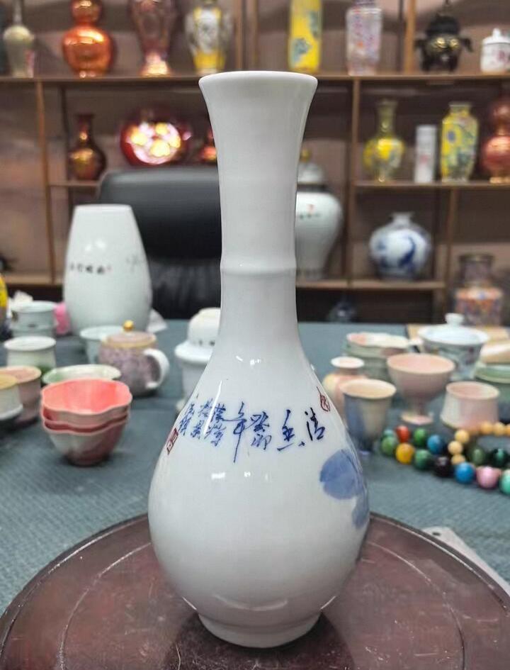 景德镇青花竹报平安花瓶，玉壶春造型，白瓷胎青花发色纯正，竹叶纹饰清新雅致。瓶身绘制竹叶纹饰，釉面莹润。无瑕疵，适合插花或家居摆件。 高约27厘米，口径5厘米，腹径11厘米