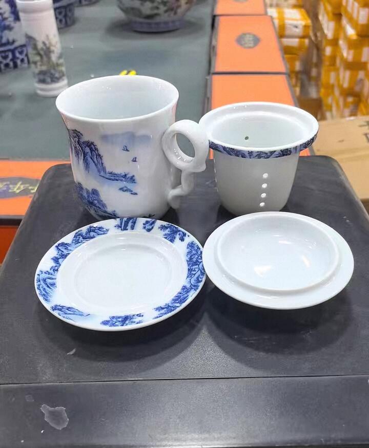 景德镇青花山水陶瓷茶杯套装，全新未使用，带盖带托盘，茶水分离设计，泡茶方便。杯身手绘山水图案，意境优美，陶瓷材质，做工细致，容量约350ml