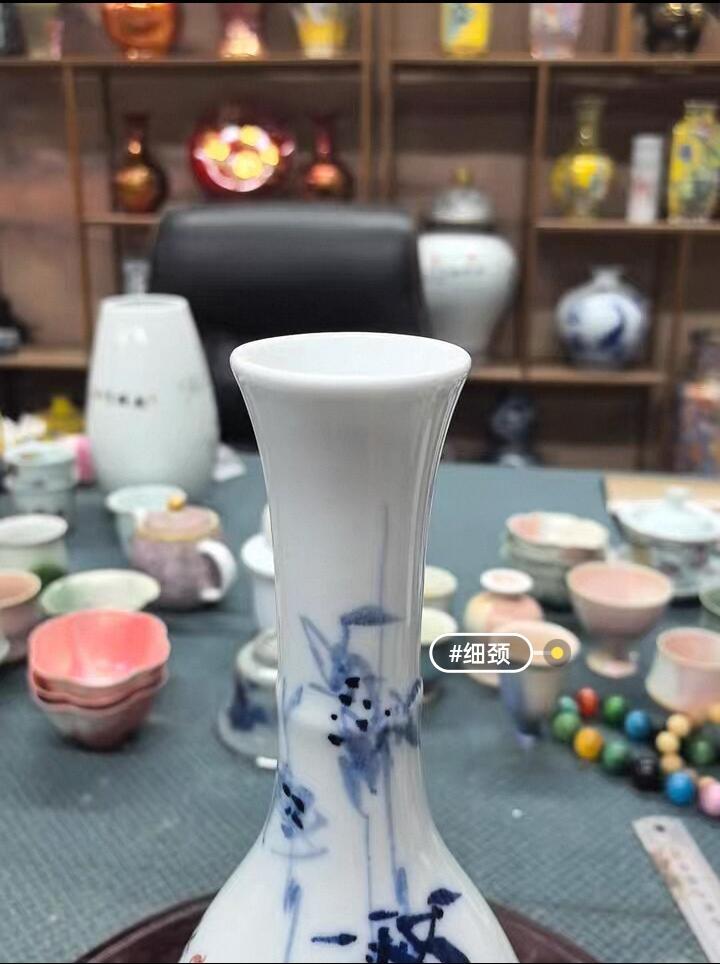 景德镇青花竹报平安花瓶，玉壶春造型，白瓷胎青花发色纯正，竹叶纹饰清新雅致。瓶身绘制竹叶纹饰，釉面莹润。无瑕疵，适合插花或家居摆件。 高约27厘米，口径5厘米，腹径11厘米
