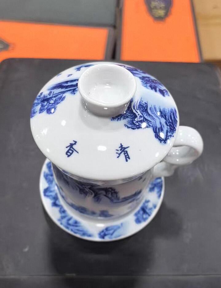 景德镇青花山水陶瓷茶杯套装，全新未使用，带盖带托盘，茶水分离设计，泡茶方便。杯身手绘山水图案，意境优美，陶瓷材质，做工细致，容量约350ml