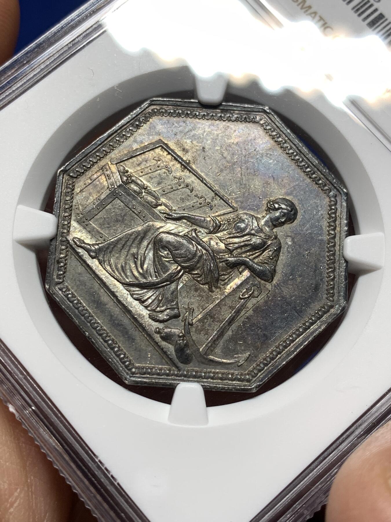 《竞宝斋》第474场 周日，周一 2场连拍 （全场包邮）欢迎送拍 NGC AU58 法国储蓄银行八角银质代币，早期无边铭，出分不易，少见款。正面：财富女神端坐，一旁的箱子里装满了财宝。