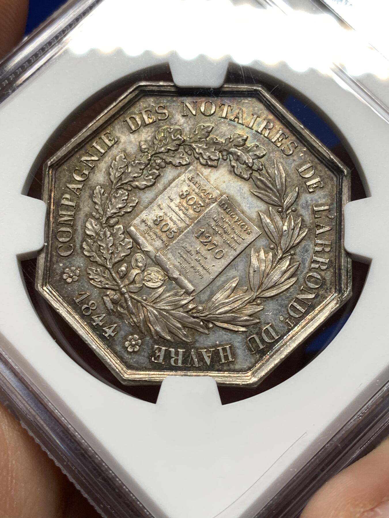 《竞宝斋》第474场 周日，周一 2场连拍 （全场包邮）欢迎送拍 NGC MS62 法国1844年勒阿弗尔公证人银质八角代币，手指铭，少见款。正面：双国王头像（圣路易与查理曼大帝），外环文字象征公证行业权威，背面：中央法典图案，外环“勒阿弗尔区公证人公司”，下方年份“1844”，周围橡叶与月桂叶花环。