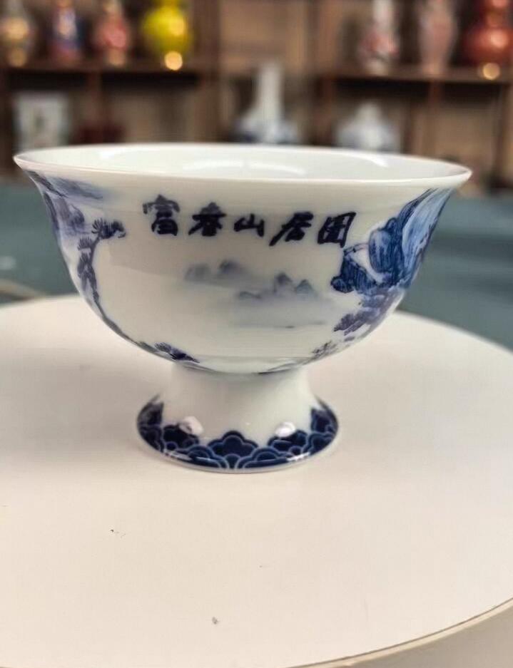 富春山居图高脚主人杯，景德镇陶瓷，青花釉下彩绘， 容量约100毫升，高度约6厘米，口径约8.8厘米。